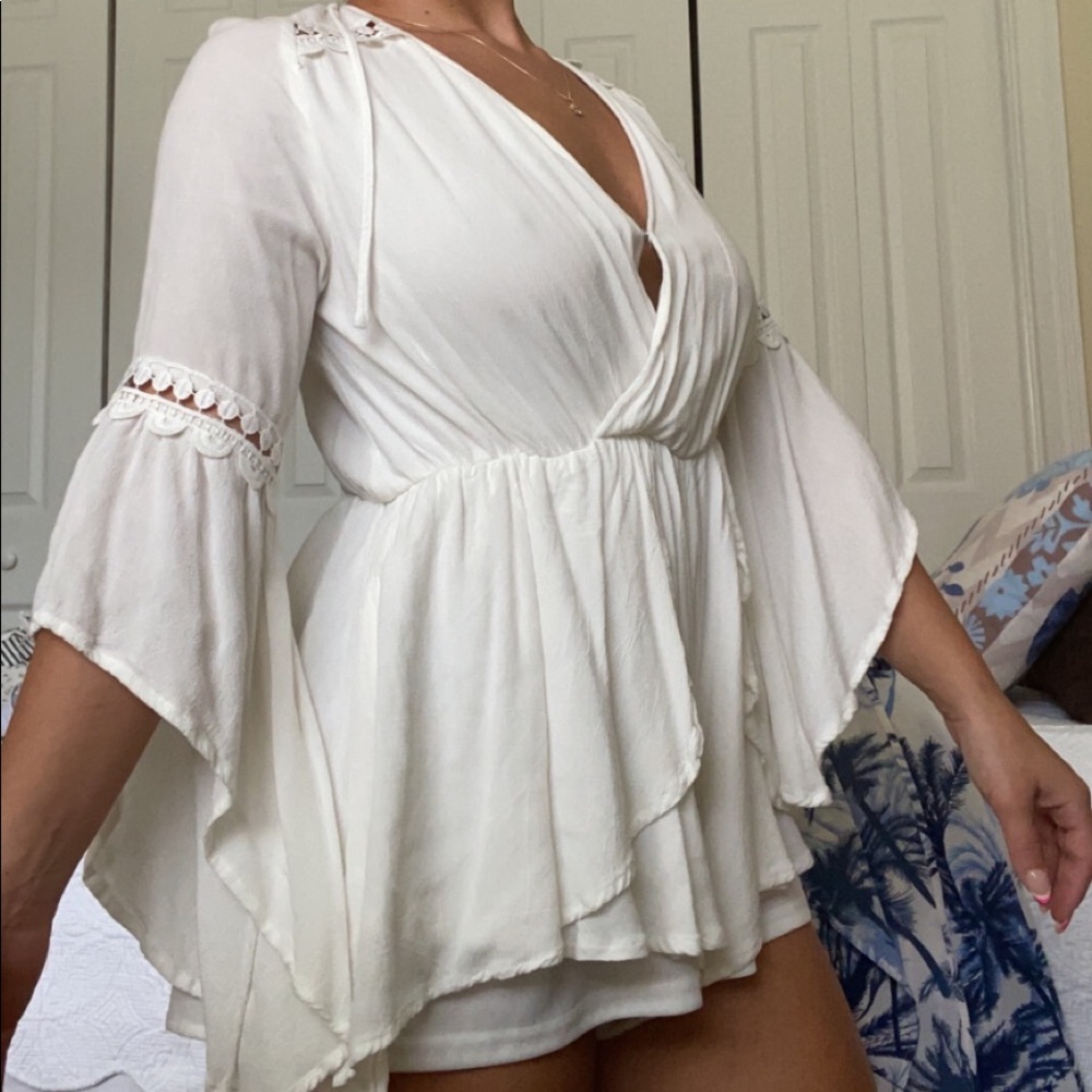 White romper with lace sleeves and a tie back